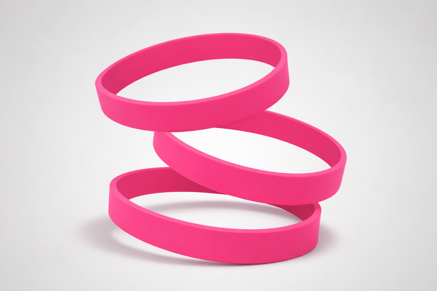 Rosa JM Band® Silikonarmbånd uten trykk på hvit bakgrunn.