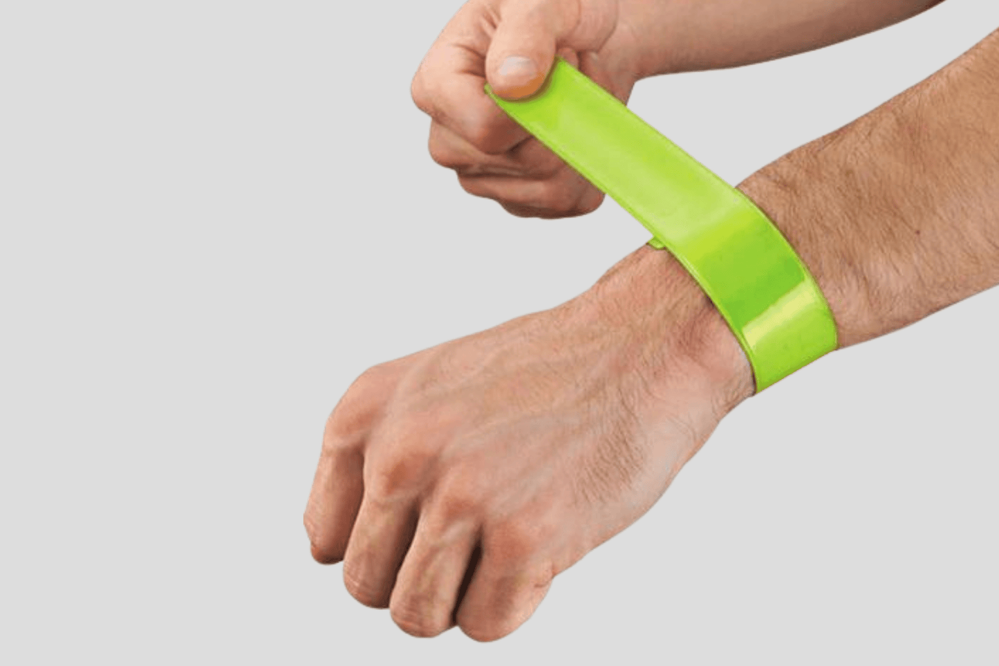 En mann holder et JM Band® Slap armbånd trykk Via e-post laget av PVC-materiale.