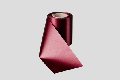 En rull med ECO satengbåndruller 100mm fra JM Band® på hvit bakgrunn.